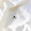 BlingbyAnvika 925 sterling silver nose ring featuring a small black bead on a white satin background