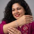 BlingbyAnvika 925 sterling silver flower bracelet with sparkling stones worn by a woman in a magenta top