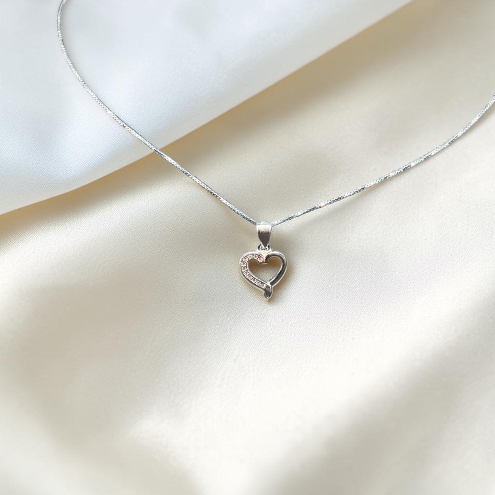 BlingbyAnvika 925 sterling silver necklace with a delicate heart pendant adorned with small clear stones.