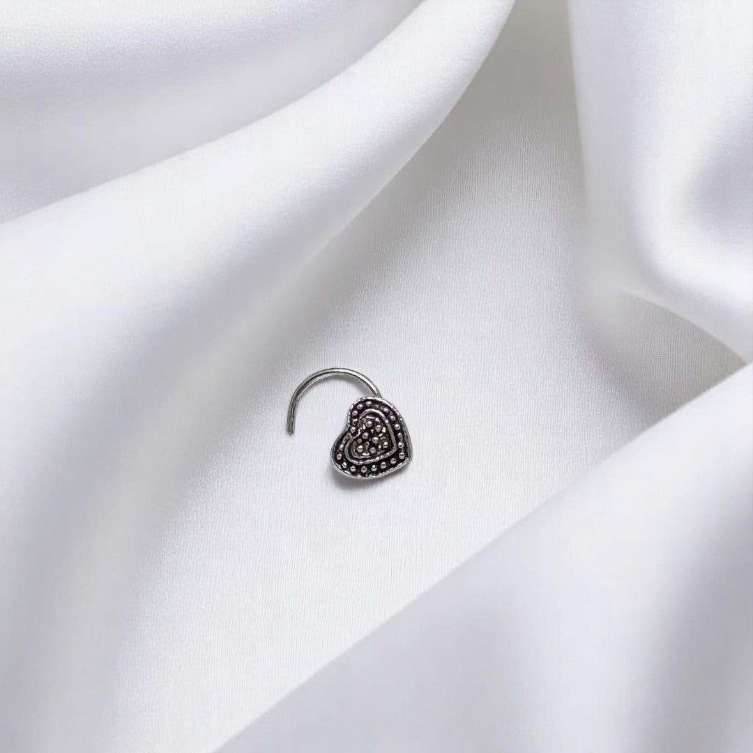 BlingbyAnvika 925 sterling silver heart-shaped nose pin with detailed beaded texture on a white satin background