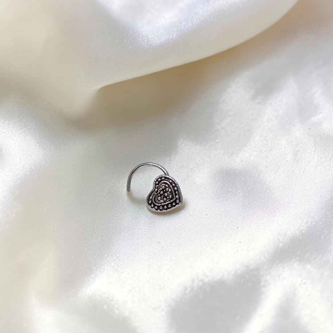 BlingbyAnvika 925 sterling silver heart-shaped nose pin with detailed beaded texture on a white satin background
