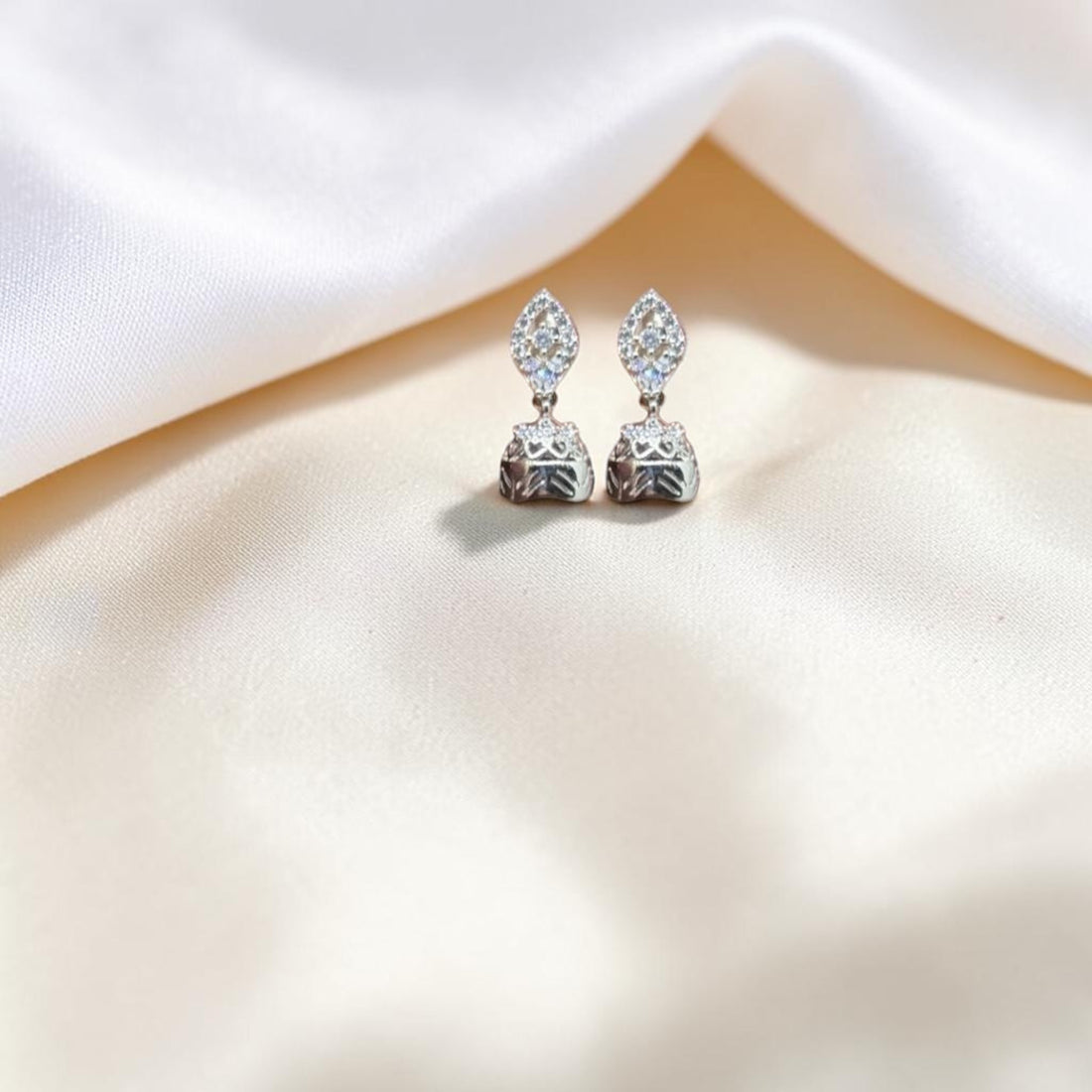 BlingbyAnvika 925 sterling silver jhumka earrings with intricate detailing and small clear stones.