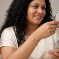 Woman wearing a BlingbyAnvika 925 sterling silver bracelet featuring a delicate pink teardrop stone on her wrist