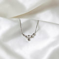 BlingbyAnvika 925 sterling silver necklace with a delicate star pendant and star accents on a curved chain.