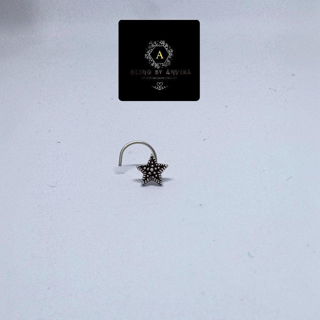 BlingbyAnvika 925 sterling silver nose pin featuring a dainty star design with a textured center on a white background