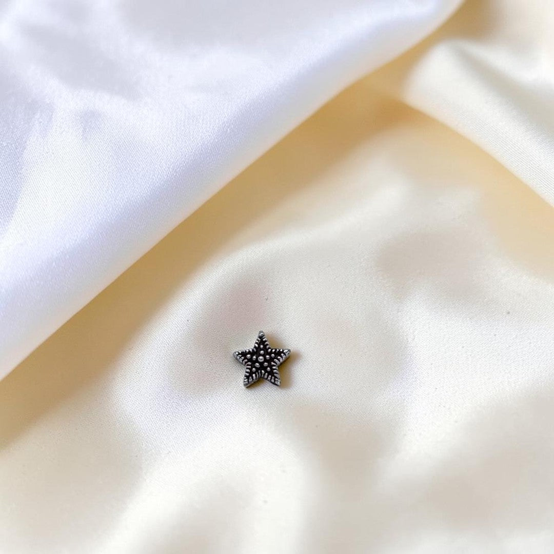 BlingbyAnvika 925 sterling silver nose pin featuring a dainty star design with a textured center on a white background