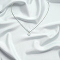 BlingbyAnvika 925 sterling silver necklace with a single brilliant stone on a delicate chain against white silk.
