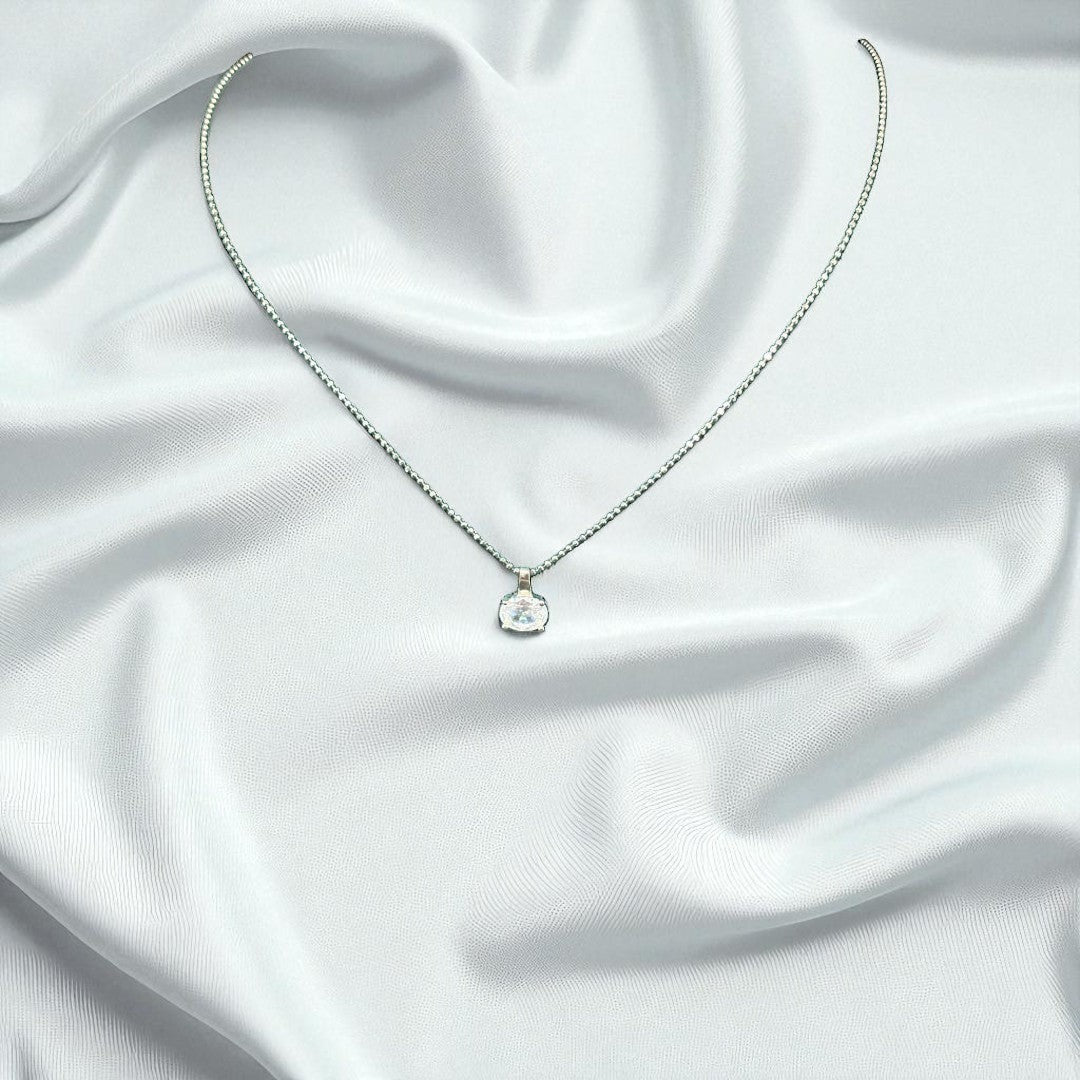 BlingbyAnvika 925 sterling silver necklace with a single brilliant stone on a delicate chain against white silk.