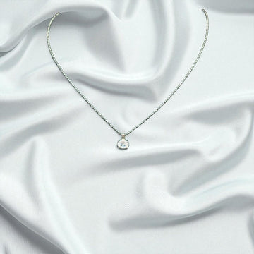 BlingbyAnvika 925 sterling silver necklace with a single brilliant stone on a delicate chain against white silk.
