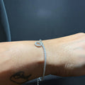 BlingbyAnvika 925 sterling silver tennis bracelet with a delicate circular charm worn on a wrist