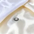 BlingbyAnvika 925 sterling silver nose ring featuring a detailed twisted rope texture on a soft white satin fabric.