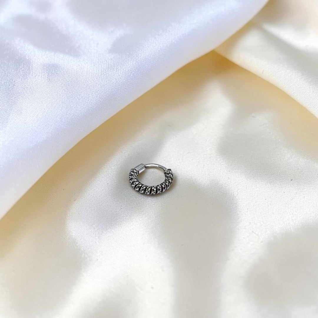 BlingbyAnvika 925 sterling silver nose ring featuring a detailed twisted rope texture on a soft white satin fabric.