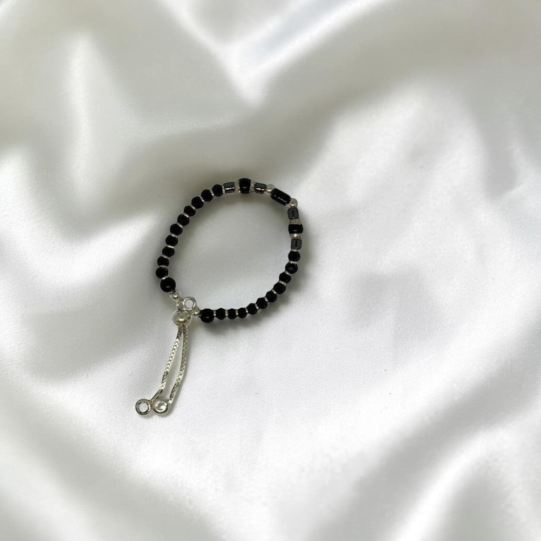BlingbyAnvika 925 silver baby bracelet with black beads and silver cubes, adjustable pull-string closure.