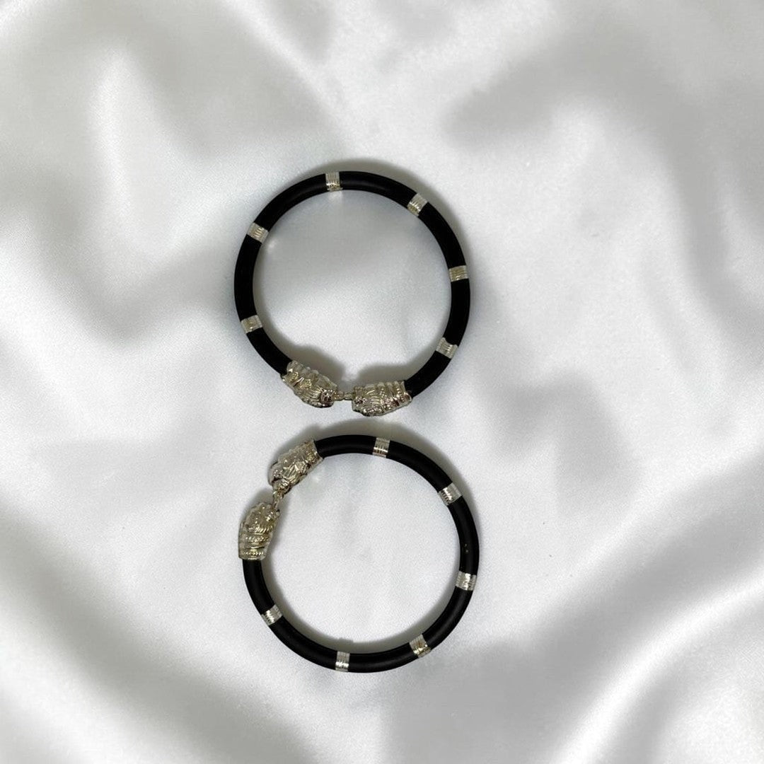 BlingbyAnvika pair of black cord bracelets with silver-tone lion head clasps and accents.