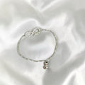 BlingbyAnvika sterling silver bracelet with infinity symbol, cubic zirconia, and 'love' charm. Features a dangling charm.