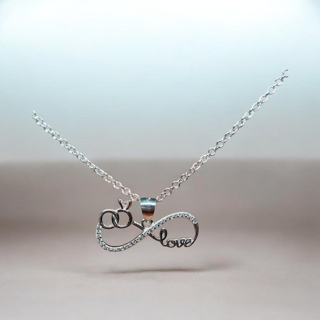 BlingbyAnvika silver pendant with infinity symbol, interlocking rings, and 'love' text, adorned with cubic zirconia.