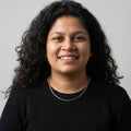 BlingbyAnvika rose gold plated 925 sterling silver snake chain necklace worn by a smiling woman in a black top.