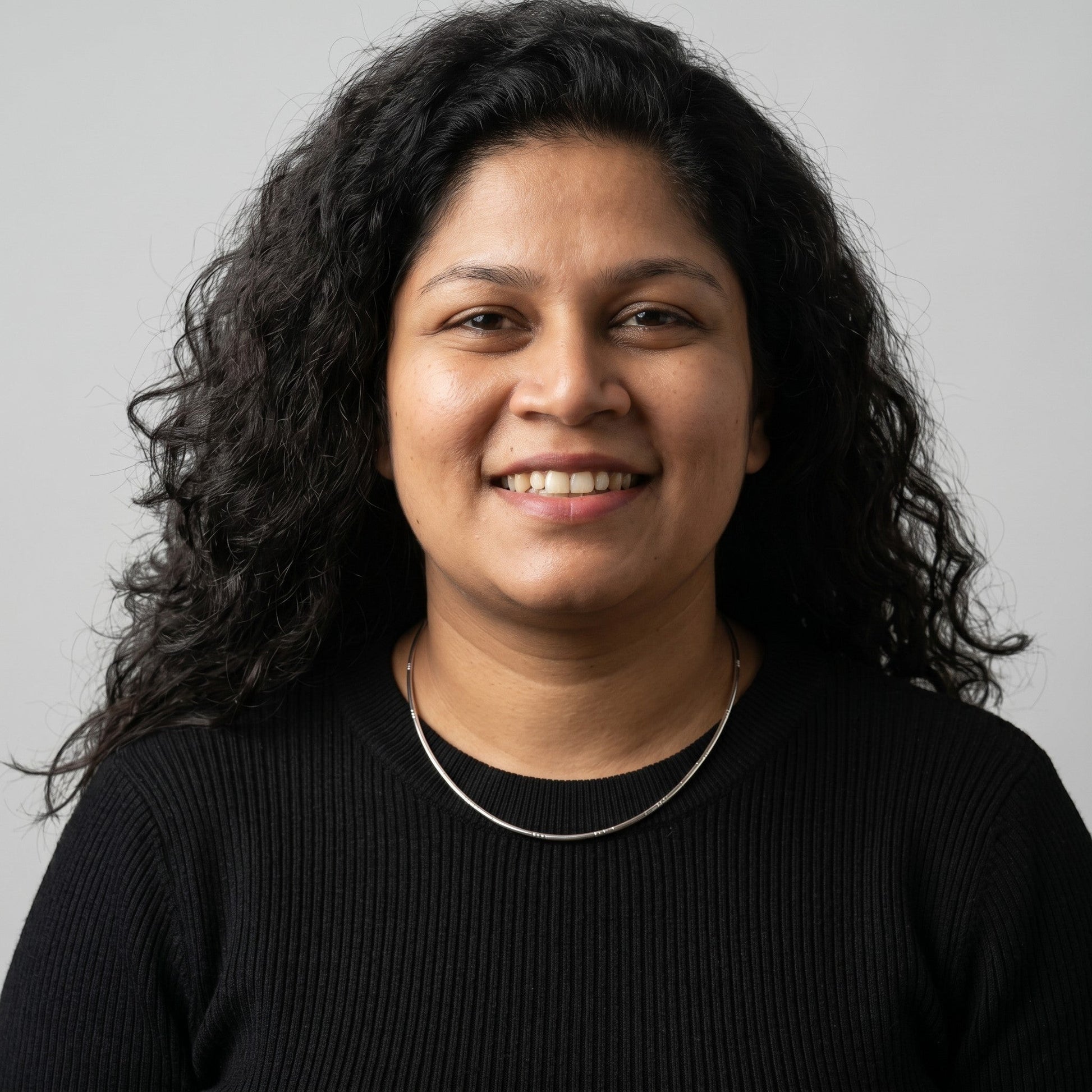 BlingbyAnvika rose gold plated 925 sterling silver snake chain necklace worn by a smiling woman in a black top.