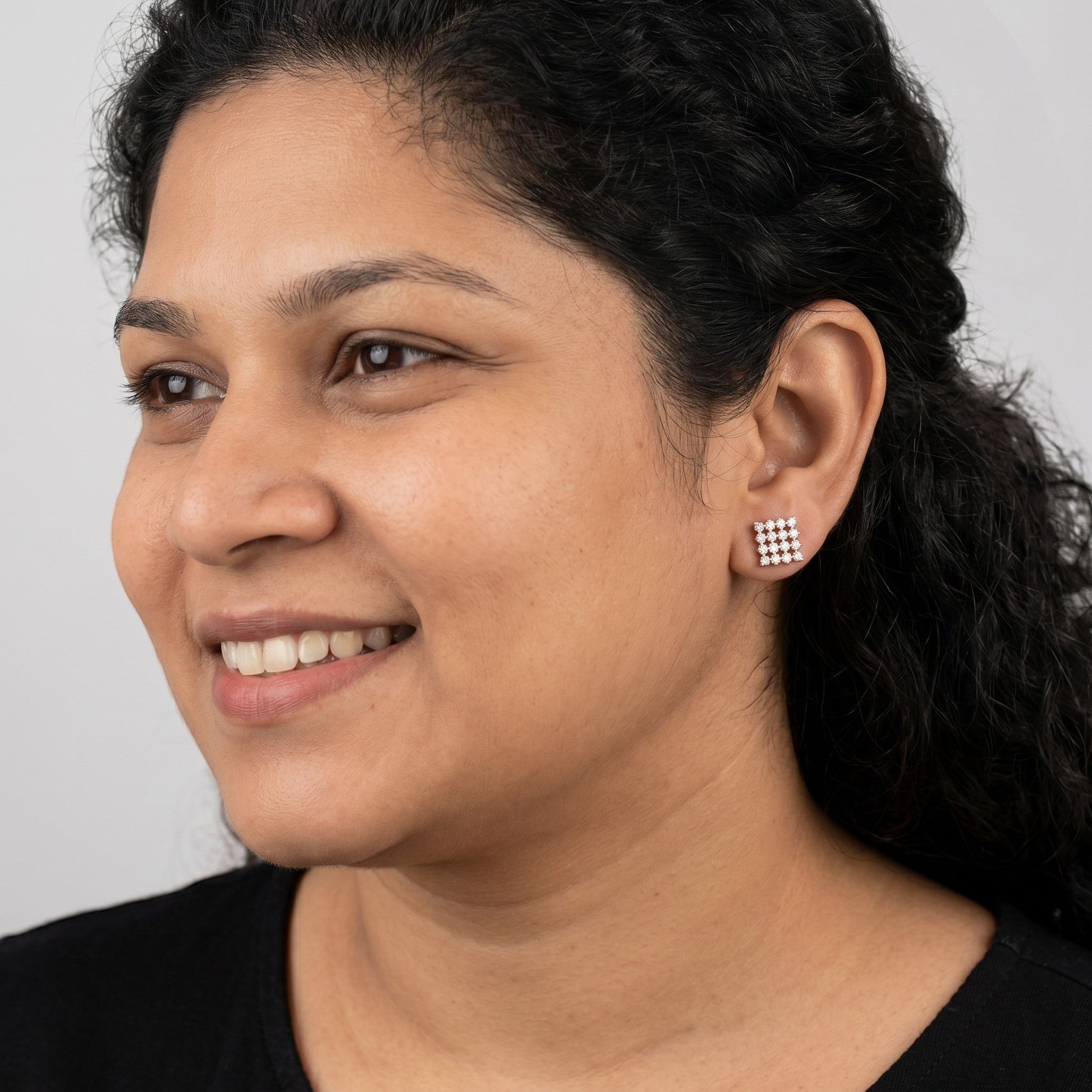 BlingbyAnvika rose gold plated 925 sterling silver square zircon stud earrings worn by a smiling woman