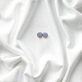 BlingbyAnvika 925 silver round blue gemstone stud earrings with polished bezel, set on white satin.