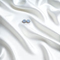 BlingbyAnvika 925 silver round blue gemstone stud earrings with polished silver-tone bezel on white satin.