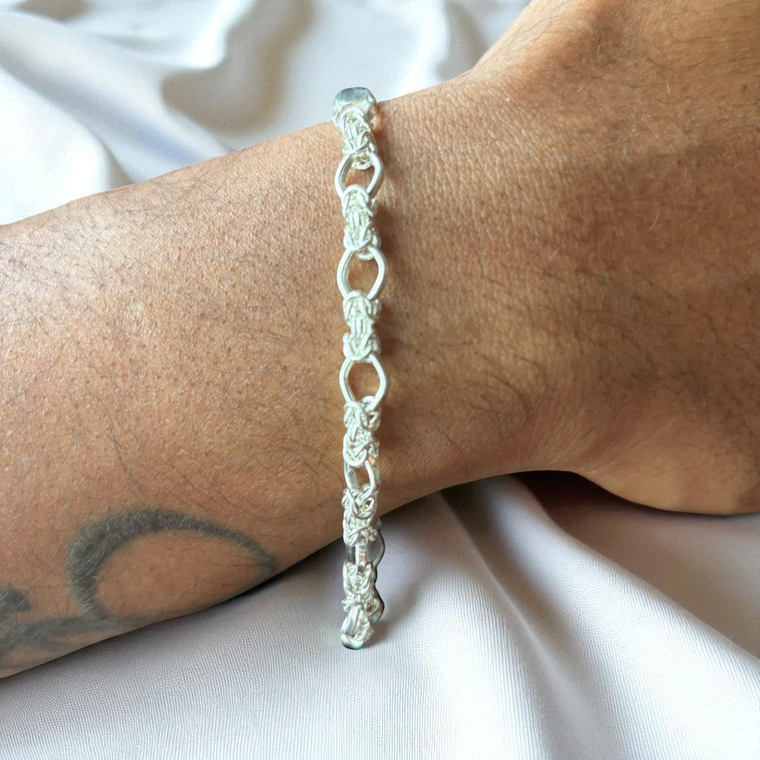 BlingbyAnvika 925 silver chain link bracelet with interlocking design and polished finish, worn on a wrist.