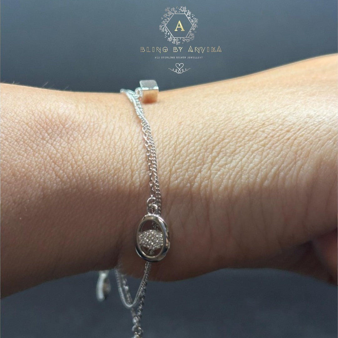 BlingbyAnvika 925 Sterling Silver bracelet with a dainty chain and oval charm encrusted with tiny stones.