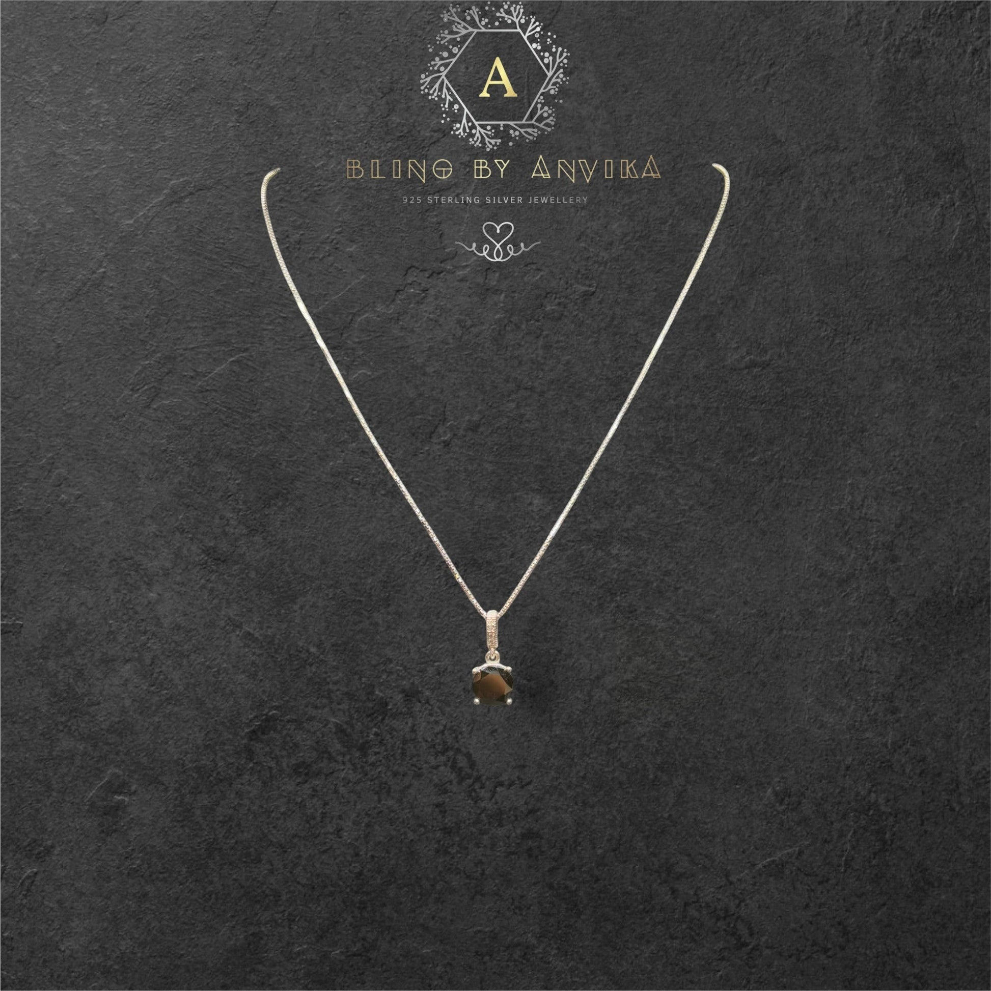 BlingbyAnvika 925 sterling silver necklace with a single, faceted dark brown stone pendant, accented with small clear stones.
