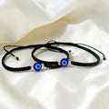 BlingbyAnvika 925 sterling silver and black thread evil eye nazarband anklets on a soft white fabric background.