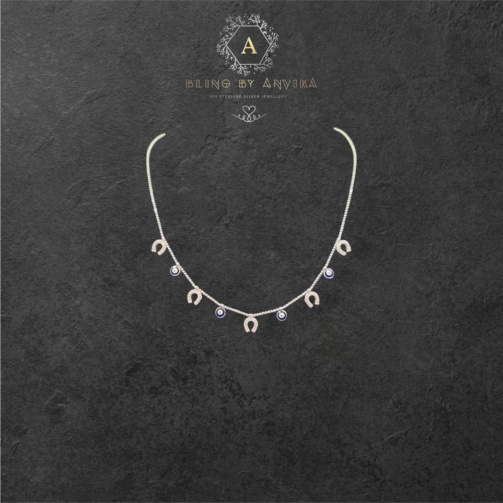 Bling by Anvika sterling silver short necklace with horseshoe and evil eye charms.