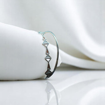 BlingbyAnvika 925 sterling silver flexi kada bracelet featuring a geometric triangle design on a white display stand.