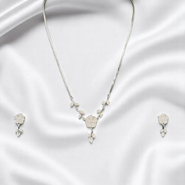 BlingbyAnvika 925 sterling silver floral necklace and matching stud earrings set on a white satin background.
