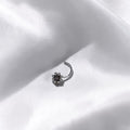 BlingbyAnvika 925 sterling silver nose pin featuring a delicate floral design on a soft white satin background.