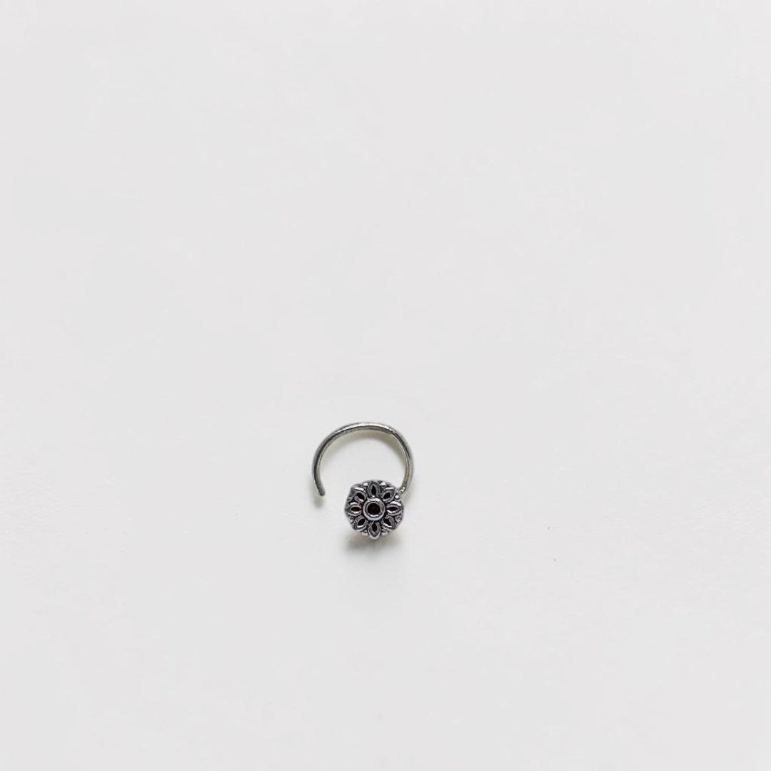BlingbyAnvika 925 sterling silver nose pin featuring a delicate floral design on a white satin background.