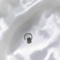 BlingbyAnvika 925 sterling silver nose pin featuring a delicate floral design on a textured grey surface