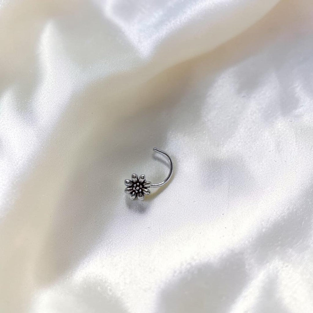 BlingbyAnvika 925 sterling silver nose pin featuring a delicate floral design on a white satin background