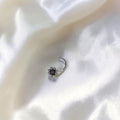 BlingbyAnvika 925 sterling silver nose pin featuring a delicate floral design on a soft white fabric background.