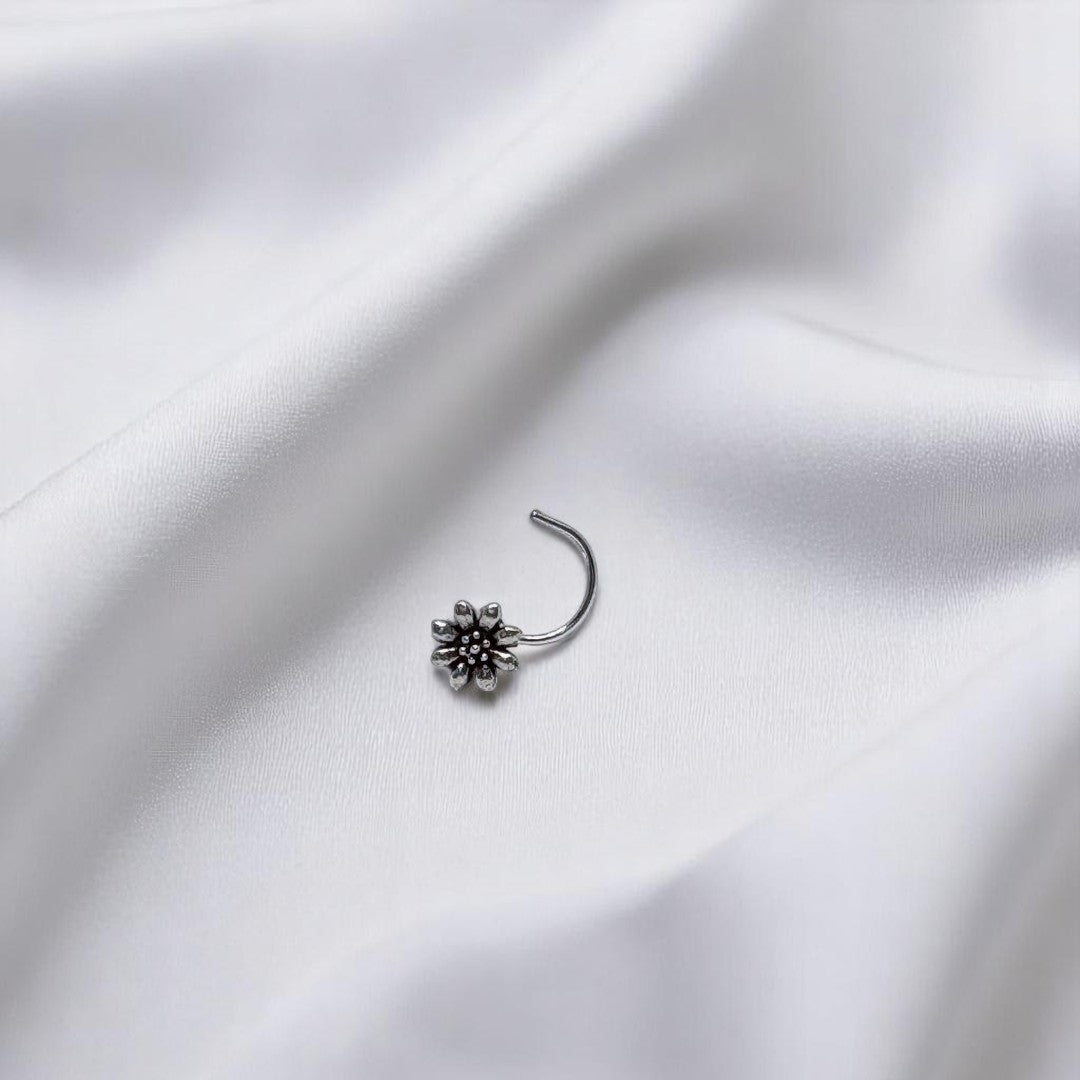 BlingbyAnvika 925 sterling silver nose pin featuring a delicate floral design on a white satin background