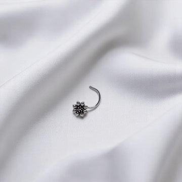 BlingbyAnvika 925 sterling silver nose pin featuring a delicate floral design on a white satin background