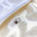 BlingbyAnvika 925 sterling silver nose pin featuring a delicate floral bloom design on a white satin background.