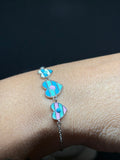 BlingbyAnvika 925 sterling silver bracelet with three colorful striped heart charms in blue, pink, and white enamel.