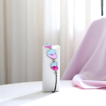 BlingbyAnvika 925 sterling silver bracelet with pastel pink and blue enamel heart charms and a delicate chain.