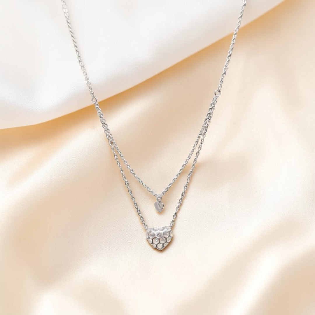 BlingbyAnvika sterling silver double-strand necklace with a small gold heart and a larger crystal-embellished silver heart pendant.
