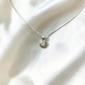 BlingbyAnvika 925 sterling silver heart pendant necklace on a delicate chain against a white satin background.