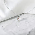 BlingbyAnvika 925 sterling silver heart pendant necklace with delicate chain on a white satin background