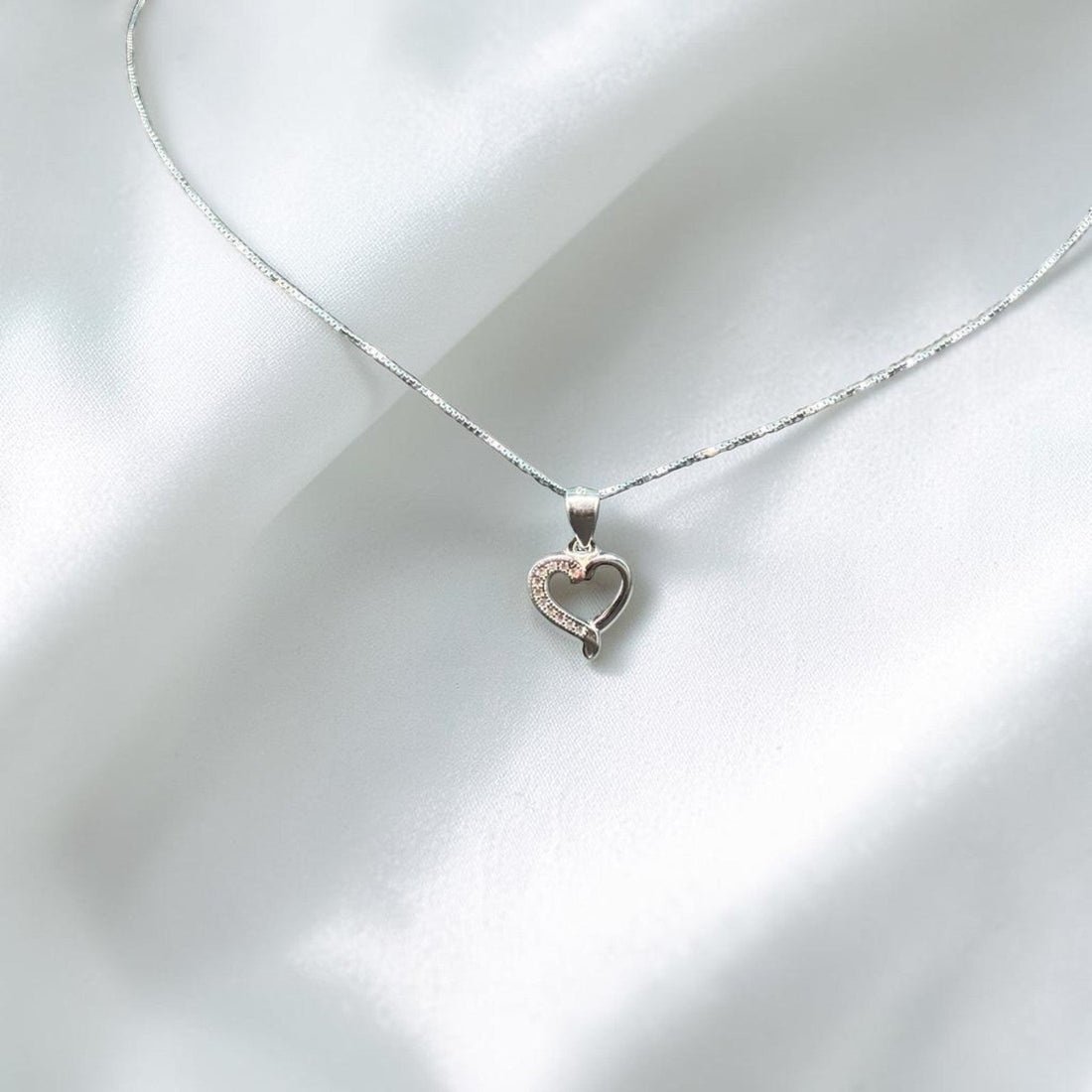 BlingbyAnvika 925 sterling silver heart pendant necklace with delicate chain on white satin fabric