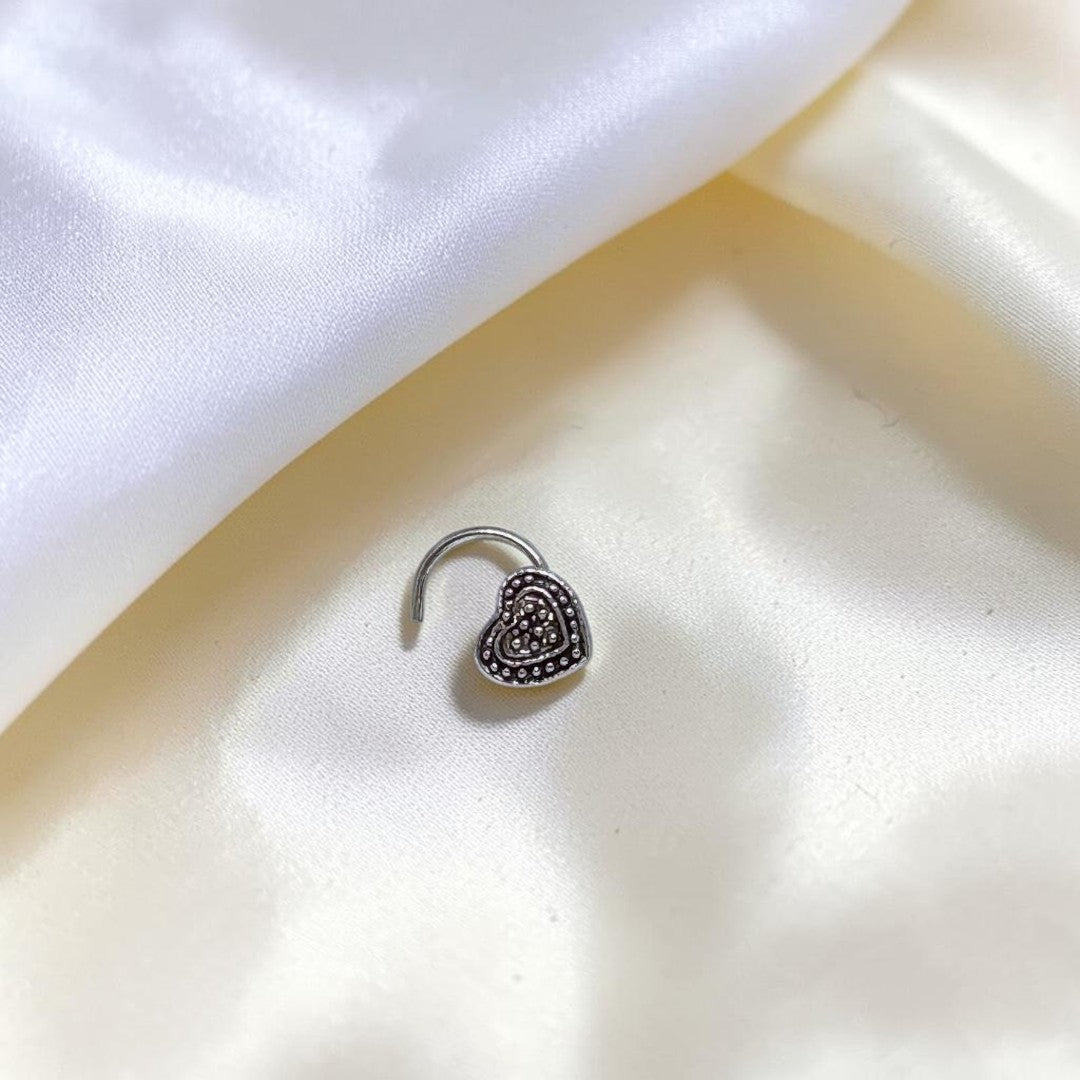 BlingbyAnvika 925 sterling silver nose pin featuring a detailed heart design on a white satin background