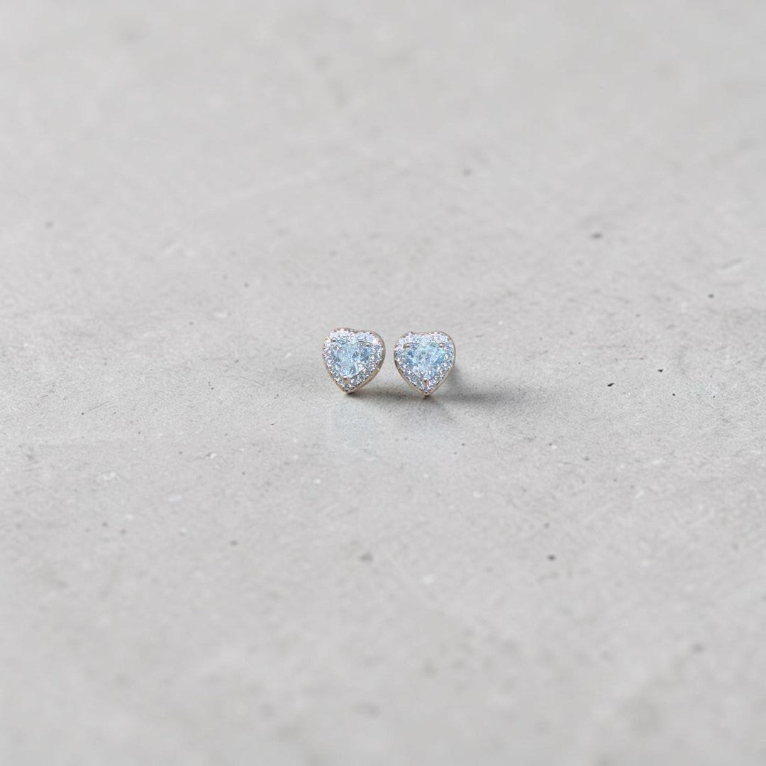 BlingbyAnvika sterling silver heart stud earrings featuring sparkling AAA-grade zircon stones on a grey background.