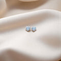 BlingbyAnvika heart-shaped stud earrings in 925 sterling silver with sparkling AAA-grade zircon stones on silk fabric.