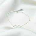BlingbyAnvika 925 sterling silver infinity symbol bracelet on a soft white satin background